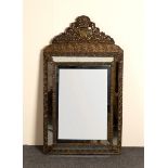 A French wall mirror with repoussé frame and bevelled glass,