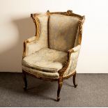A Louis XV style fauteuil with carved and gilded frame, upholstered seat, wing back and padded arms,