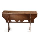 A 16th Century style oak long boarded bench, plank top with a deep pierced base below,