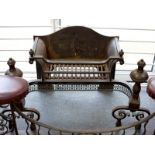 A fine burnished steel fire grate with vase-shaped finials, pierced apron and scroll feet,