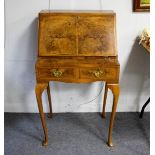 A crossbanded burr wood bureau, the hinged fall flap enclosing drawers and pigeonholes,