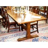 An oak refectory table, on square end standards united by a central stretcher on sledge feet,