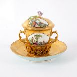 A Berlin chocolate cup, cover and stand painted rural reserves on a gilt ground,