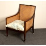 A Regency mahogany framed bergère chair with cane back, sides and seat,