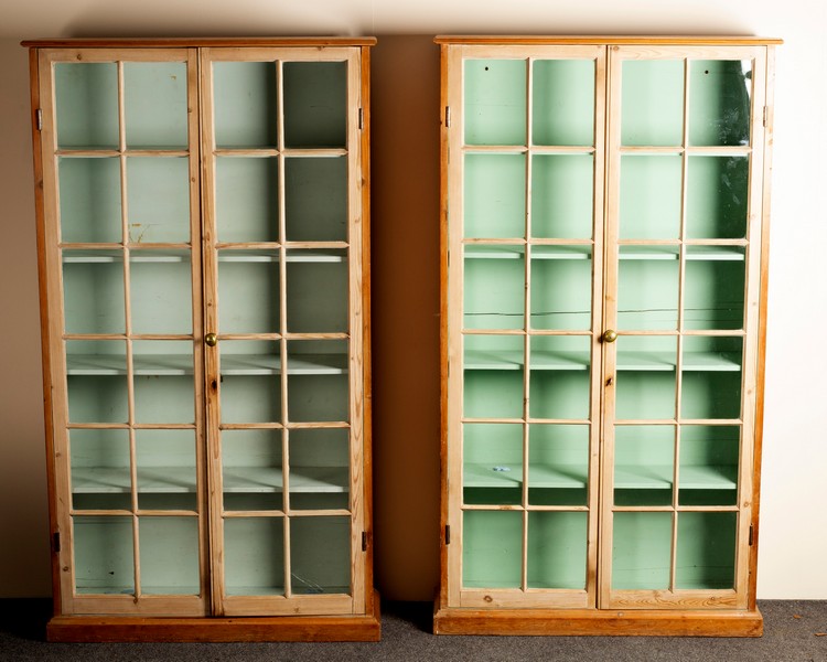 A pair of pine display cases, each enclosed by a pair of glazed doors,