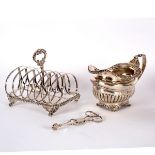 A George III silver jug, London 1819, with gadrooned rim and half-ribbed sides, a silver toast rack,