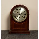 A mahogany arch-top mantel clock with eight-day chiming movement,