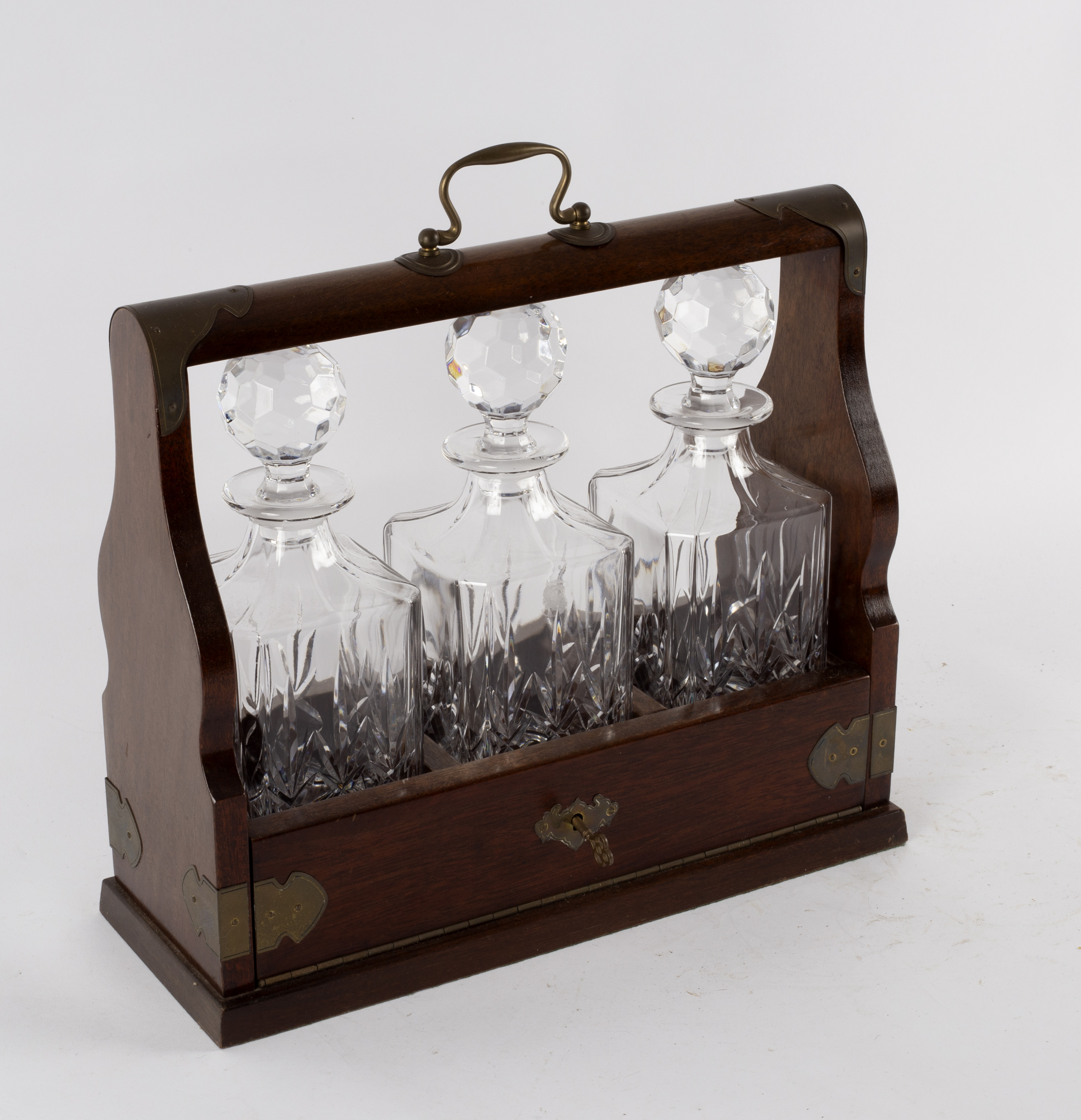 An Edwardian oak cased tantalus fitted three cut glass decanters,
