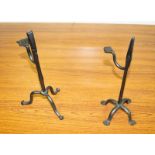 Two 18th Century style wrought iron rush-light holders with weighted handles, on tripod bases,