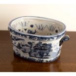A large blue and white willow pattern two-handled foot bath,