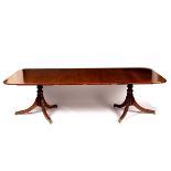 A mahogany two-pillar dining table, fitted extra leaves,