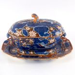A pearlware soup tureen, cover and stand painted flowers, dragons on a red ground,