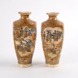 A pair of Japanese Satsuma square section bottle vases, painted with figures in fan-shaped panels,