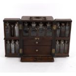 A 19th Century apothecary box, the hinged doors concealing compartments containing medicine bottles,