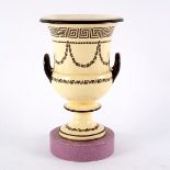 A creamware two-handled vase on a pedestal base and a Staffordshire spittoon and liner