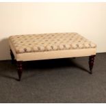 A low upholstered stool on turned legs,