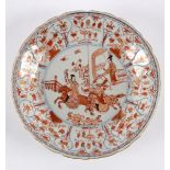 A Chinese iron red and gilt dish, Kangxi Period, painted with two figures on horseback,