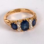 An Edwardian sapphire and diamond ring in an 18ct yellow gold scroll setting,