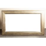 A large modern mirror, the frame with dimpled finish, the bevelled glass,