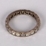 A diamond eternity ring set in white precious metal,