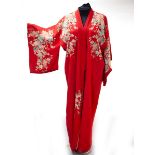 A Japanese red silk crepe kimono, circa 1900, decorated sprays of flowers,