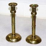 A pair of Arts & Crafts brass candlesticks, of plain column form on domed circular bases, 24.