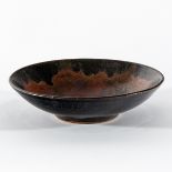 Henry Hammond (British 1914-1986), a shallow stoneware bowl, the interior glazed in mottled red,