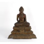 A Thai metal Buddha seated cross-legged on a throne,