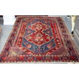 A Hamadan rug with central floral pole decoration on a red ground,