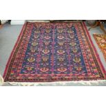 An Eastern rug decorated stylised designs on a blue ground within a multi figured border,