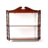 A set of Victorian mahogany wall shelves with scrolling crest and turned supports,