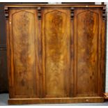A Victorian mahogany wardrobe enclosed by three doors,