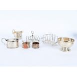 A silver mustard pot and cover, London 1924, a cream jug, two toast racks, two small ladles,