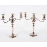 A pair of silver plated two-branch three-light table lights on circular bases,