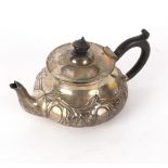 A silver teapot, E & D, London 1905, of circular form embossed foliage,