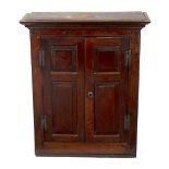 An 18th Century oak cupboard, enclosed by twin panelled doors, 83.
