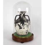 A plaster replica of the Portland vase under a glass dome,