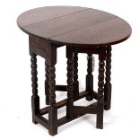 An oak oval two-flap gate leg table, on bobbin-turned legs and square stretchers, 59.