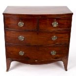 An early 19th Century mahogany bowfront chest of two short over two long drawers on splay feet,