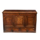 An oak chest with panelled front, fitted two drawers,