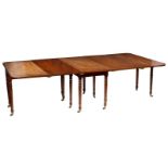 A George IV mahogany dining table with rounded ends on twelve turned legs, fitted two extra leaves,