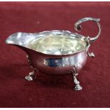 A George II silver butter boat, London 1750, with scroll handle on three scroll feet, crested, 11.