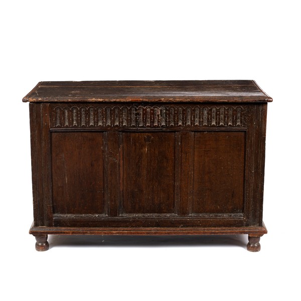 An 18th Century oak chest with carved frieze and panelled front,