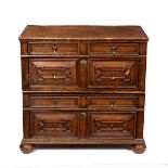 A late 17th Century oak chest, fitted four drawers with geometric moulded fronts on bun feet,