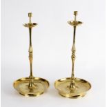 A pair of brass candlesticks, Chinese, 19th Century, with drip trays,