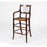 A child's high chair with spindle back and wicker seat,
