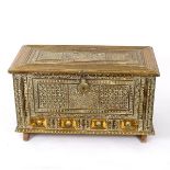 A Chinese brass covered chest with hinged covers and embossed decoration,