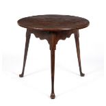 An early 19th Century elm cricket table, on round legs with pad feet,