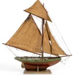 A wooden pond yacht with rigging and stand,