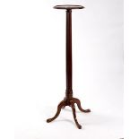 A mahogany plant pedestal with reeded column and quadruple support,